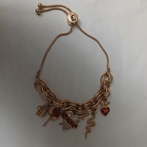 Juicy Couture Gold Bracelet with various charms including a crown, heart, & Logo